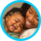 A mother smiling while holding her baby